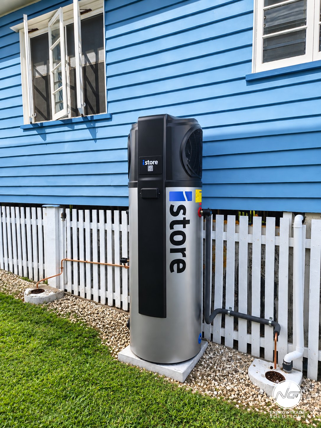 iStore heat pump hot water system installed beside a blue weatherboard home.