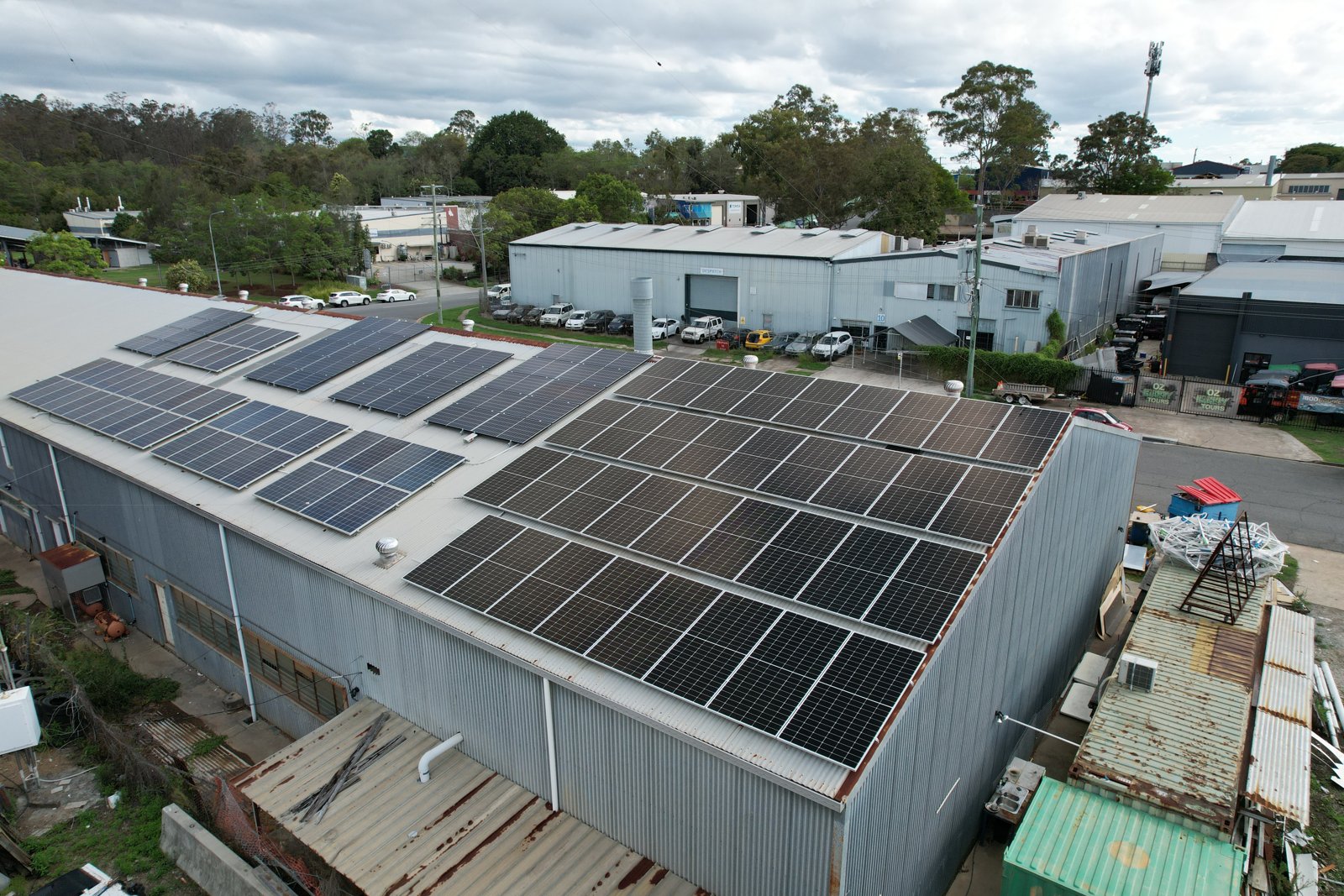 Aerial view of solar panels installed on a commercial warehouse roof.