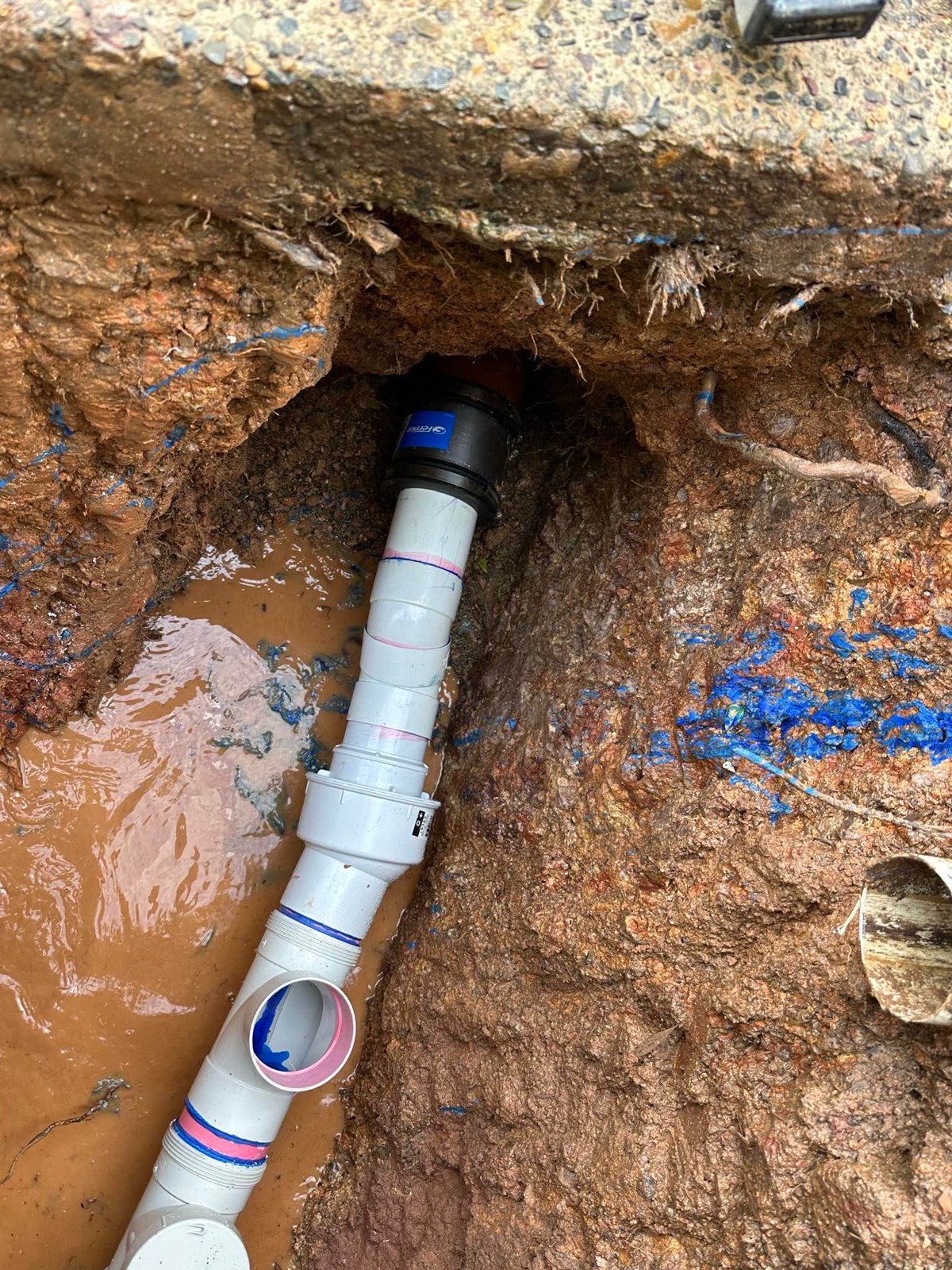 Excavated drain pipework during a repair.