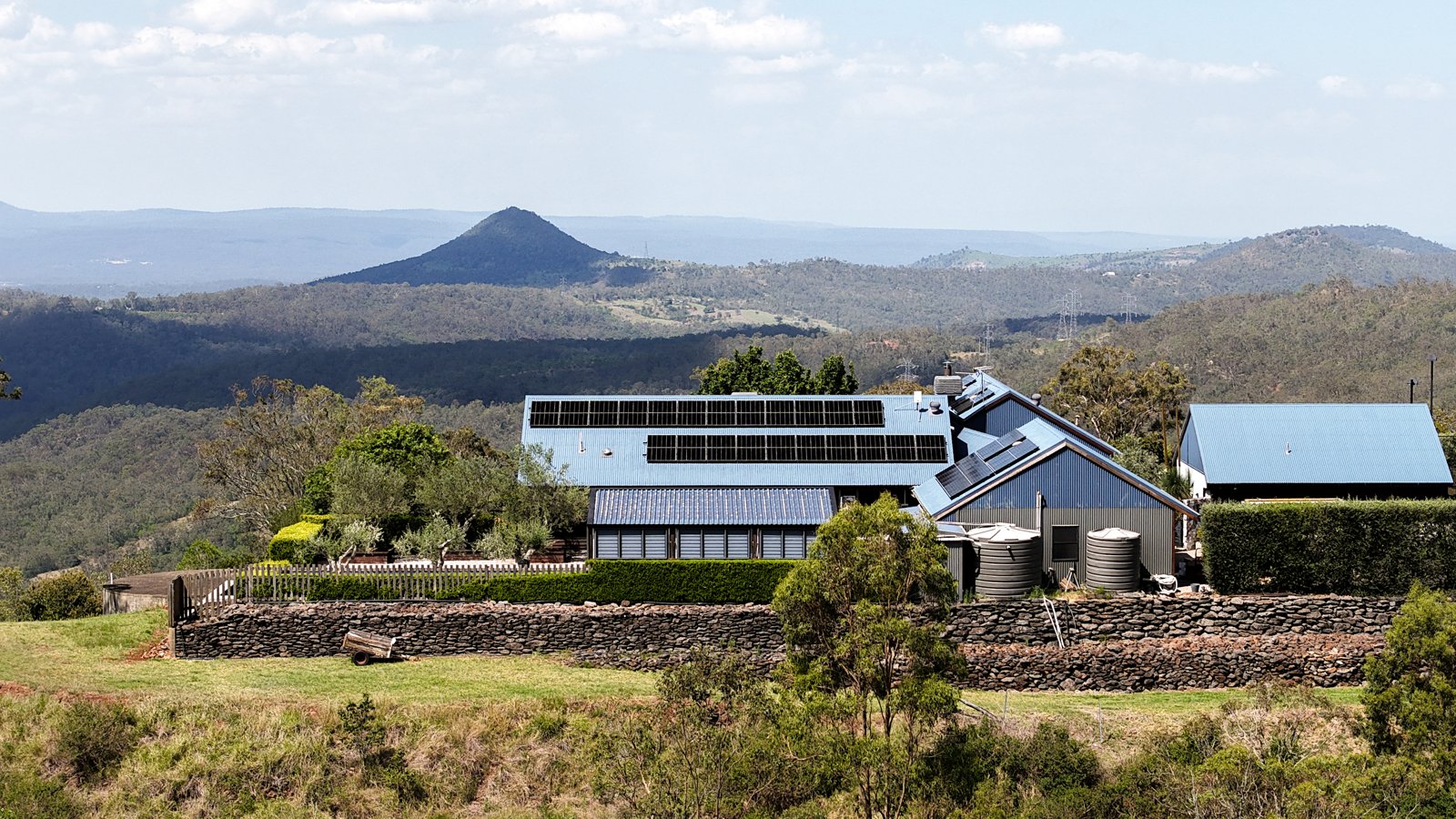 Home with rooftop solar panels overlooking a rural landscape.
